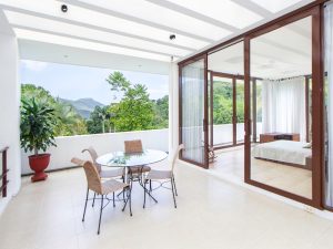 Stylish modern balcony surrounded by greenery, showcasing potential areas to inspect for a leaky balcony.